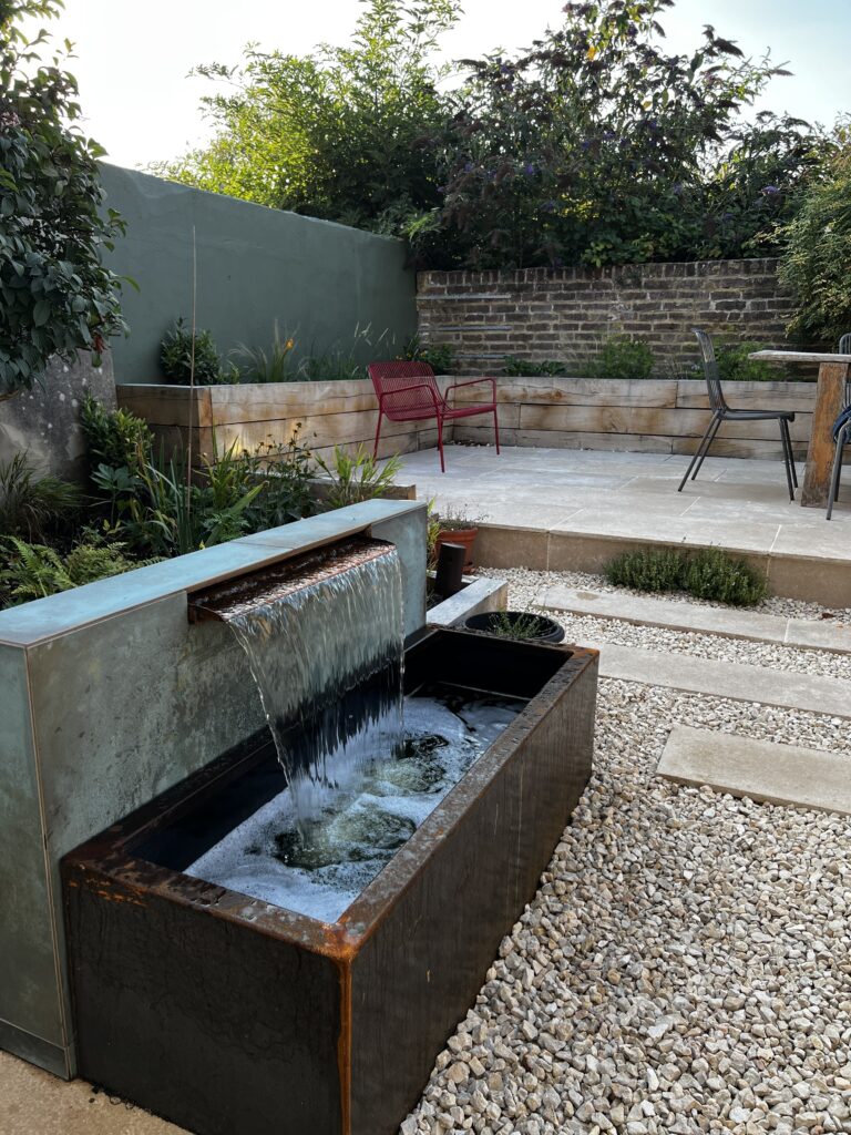 A waterfall trough feature in a garden