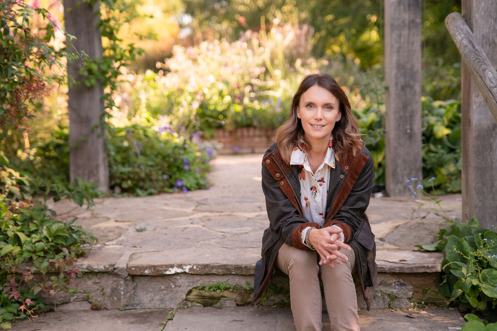 Garden Design Sussex Garden Designer Victoria Rumens sitting on stone steps leading into a stunning Sussex Garden.