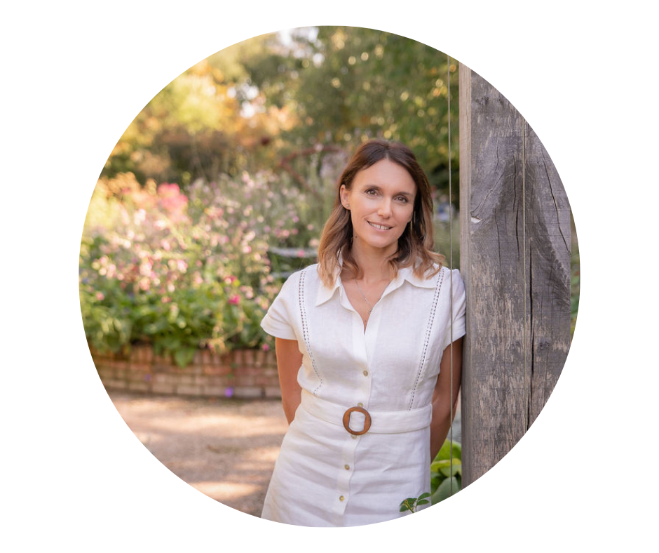 Garden designer Victoria Rumens leaning in a beautiful garden in Sussex